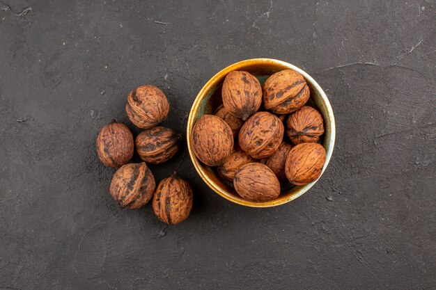 Top view of fresh walnuts on dark surface