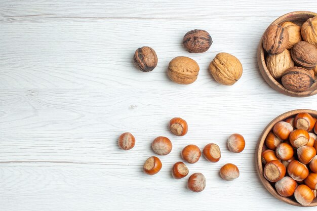 Top view fresh walnuts with hazelnuts on a white table