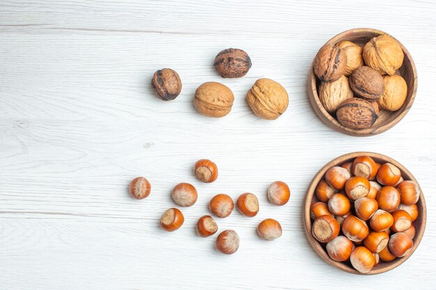 Top view fresh walnuts with hazelnuts on white table