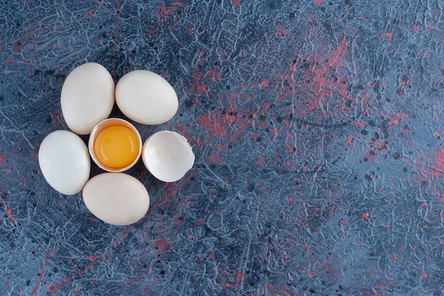 Foto gratuita vista dall'alto dell'uovo di gallina bianco fresco rotto con tuorlo e albume.