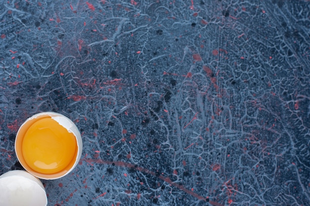 Vista dall'alto dell'uovo di gallina bianco fresco rotto con tuorlo e albume.