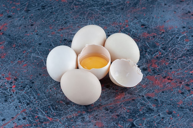 Вид сверху на свежее белое куриное яйцо, разбитое желтком и яичным белком