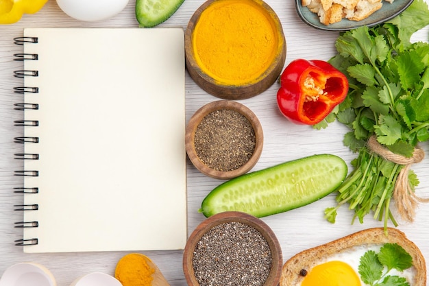 Foto gratuita vista dall'alto uova bianche fresche con verdure e condimenti su sfondo bianco pasto colore cibo insalata colazione matura