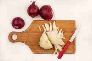 Free photo top view of fresh white onion on a wooden kitchen board with knife with red onions isolated on a white surface