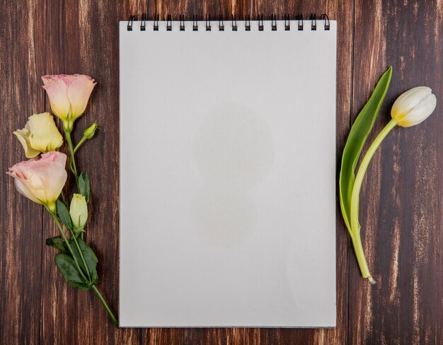 Top view of fresh white tulip with roses on a wooden background with copy space