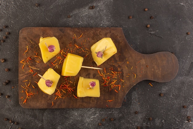 Вид сверху свежий желтый сыр с коричневыми кофейными семечками на сером столе еда закуска