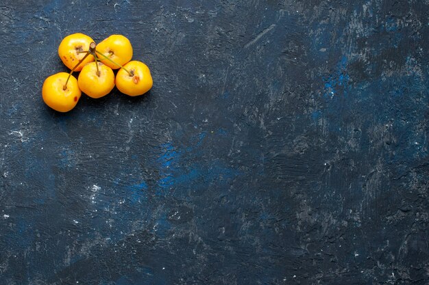 暗い机の上に分離された新鮮な黄色のサクランボ、フルーツベリーの新鮮なまろやかな上面図