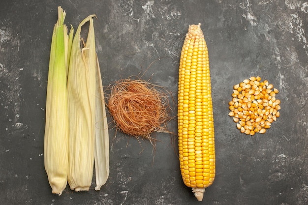 Free photo top view fresh yellow corns on dark background