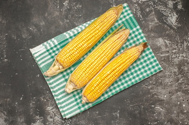 Top view fresh yellow corns on a dark-grey background