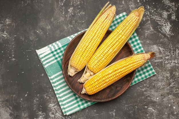 Top view fresh yellow corns on the dark-grey background