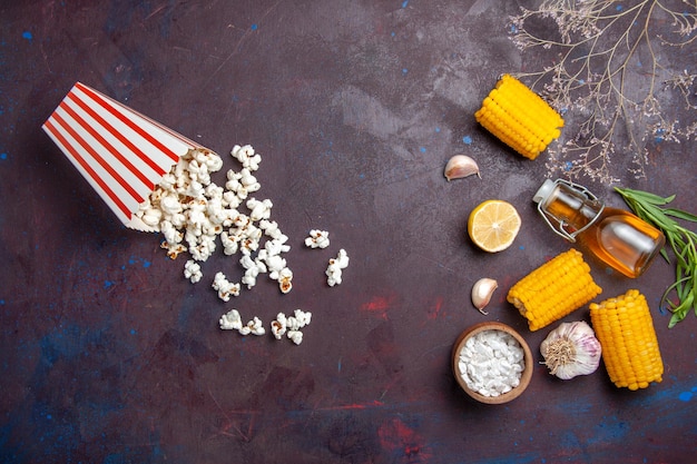 Vista dall'alto calli gialli freschi con popcorn sulla superficie scura snack di mais crudo fresco