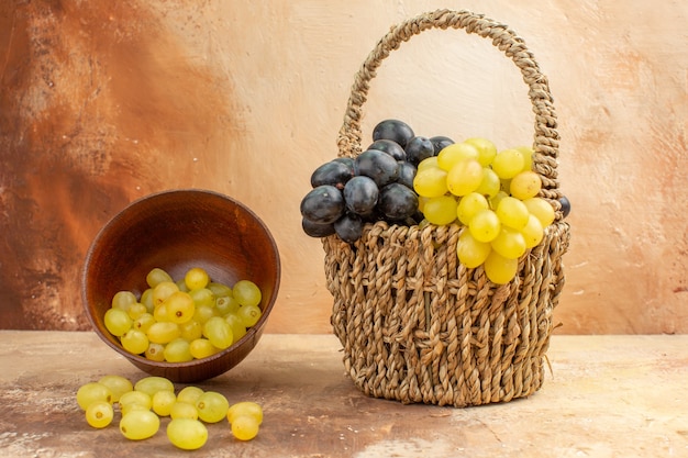 Top view of fresh yellow grapes fallen from a small pot and in a basket