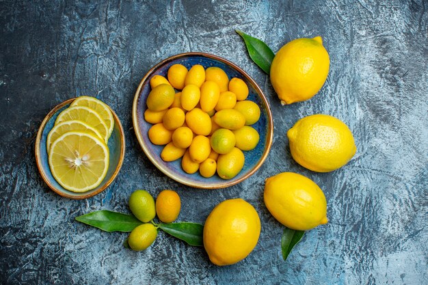 Вид сверху свежие желтые лимоны на светло-темном фоне