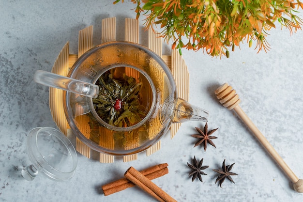 Top view of freshly brewed tea on grey surface . 