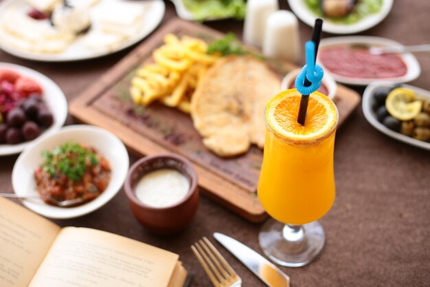 Вид сверху свежевыжатый апельсиновый сок с ломтиком апельсина на сервировочном столе