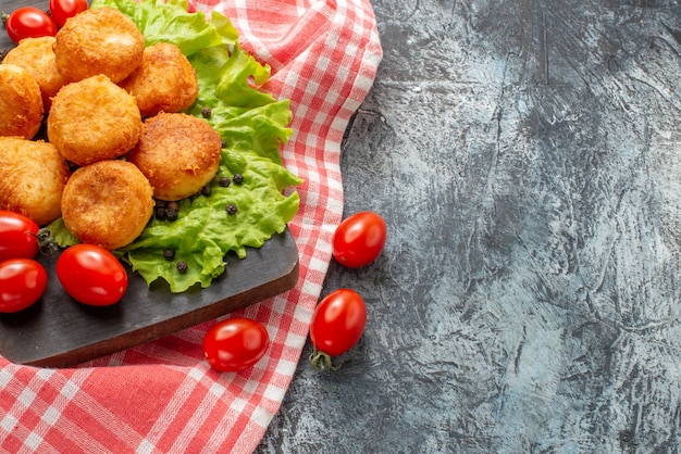 Top view fried cheese balls cherry tomatoes on cutting board free space