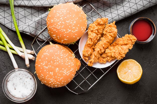 Top view fried chicken and burgers on tray with sauces