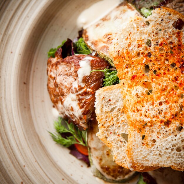 Top view fried chicken fillet with crackers and greens in round plate