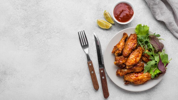 Top view of fried chicken on plate with salad and sauce