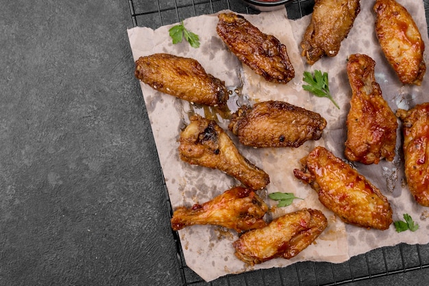 Top view of fried chicken wings and legs on cooling rack with copy space