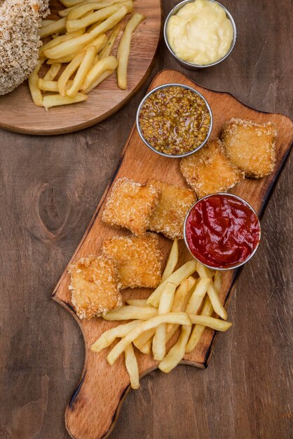 Top view of fried chicken with french fries and different types of sauce