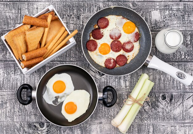 Top view of fried eggs with toasts on white surface horizontal