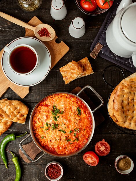 Top view of fried eggs with tomatoes in a pan