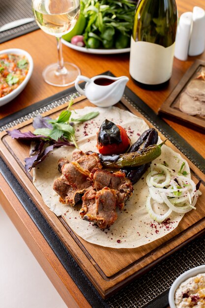 Вид сверху жареные мясные кости с жареными овощами, белое вино и соус на столе, еда, ужин, ужин, ресторан