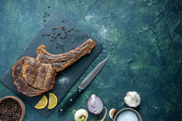 Вид сверху жареный кусок мяса на темном фоне мясное блюдо жаркое цвет приготовление ужина из ребер животных