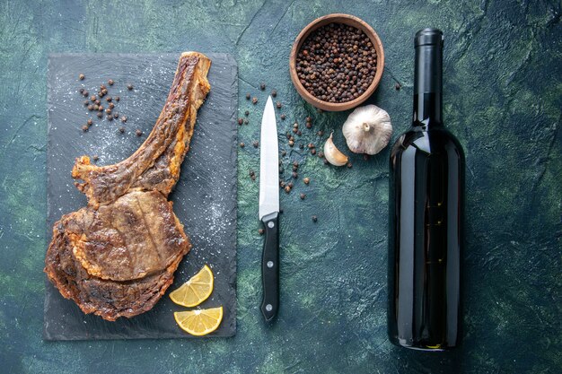 Top view fried meat slice with lemon slices and pepper on dark background meat cooking rib dinner food dish fry animal