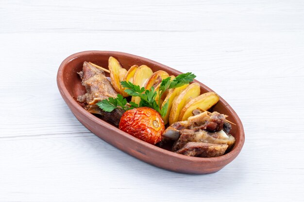 Top view of fried meat with greens and baked plums inside brown plate on white, food meal meat dish dinner vegetable