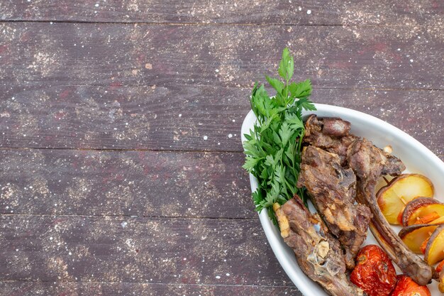 갈색 나무 책상, 음식 식사 고기 요리 저녁 식사에 접시 안에 채소와 구운 자두와 튀긴 고기의 상위 뷰