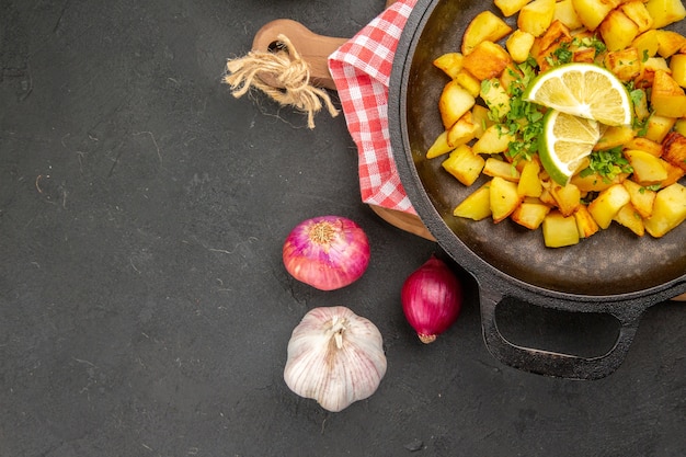 Free photo top view fried potatoes inside pan with lemon on dark background