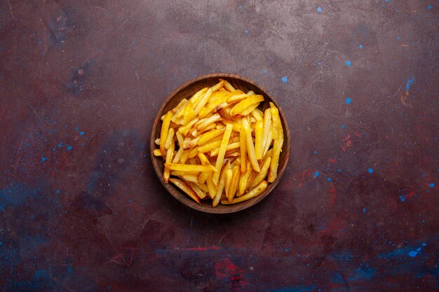 Top view fried potatoes tasty french fries inside plate on the dark surface