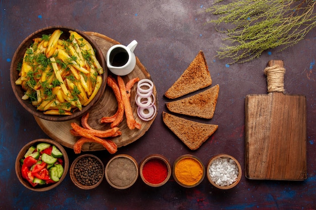 Top view fried potatoes with seasonings bread and different vegetables on dark surface