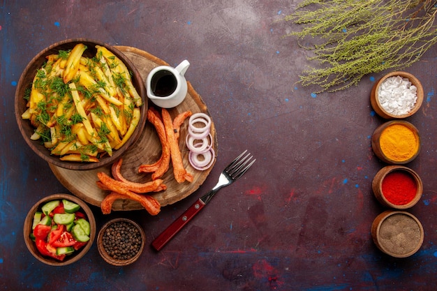 Free photo top view fried potatoes with seasonings and different vegetables on dark surface