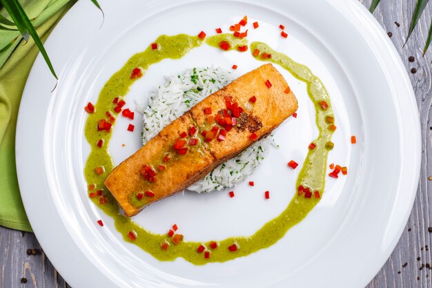 Top view fried red fish with rice and sauce on a plate