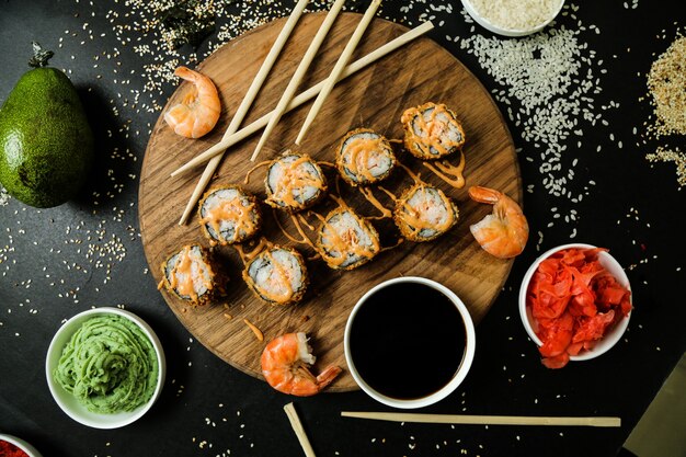 Top view fried rolls on a stand with sauce and shrimp and ginger wasabi and soy sauce