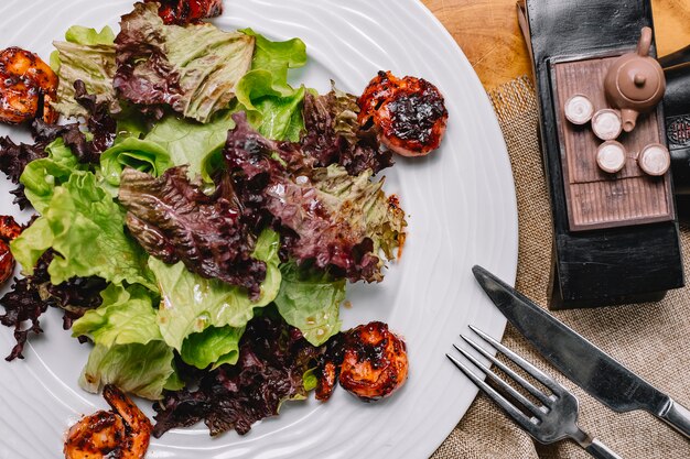 Top view fried shrimps with salad leaves