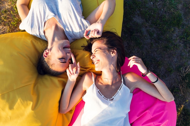 Top view friends smiling on colorful beanbags 