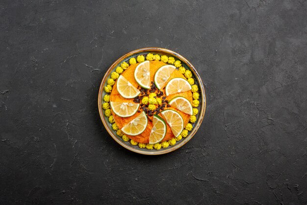 Top view from afar appetizing cake appetizing cake with oranges on the grey plate on the dark table