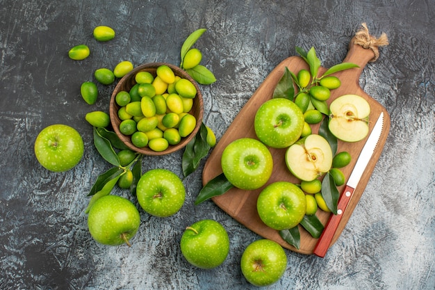 Free photo top view from afar apples board of the appetizing green apples knife citrus fruits