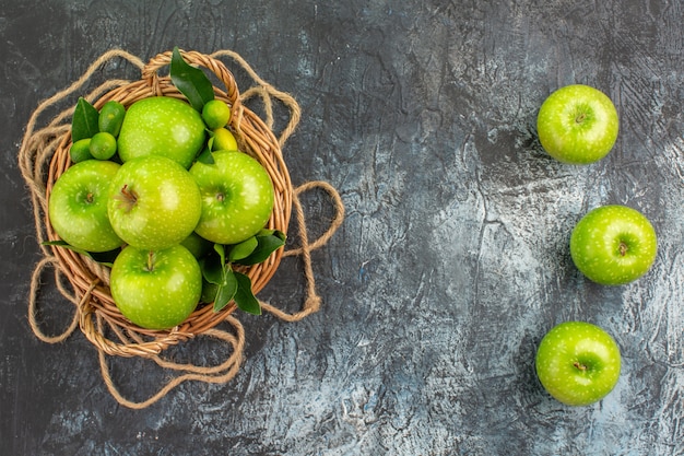 Top view from afar apples rope basket of apples with leaves on the table