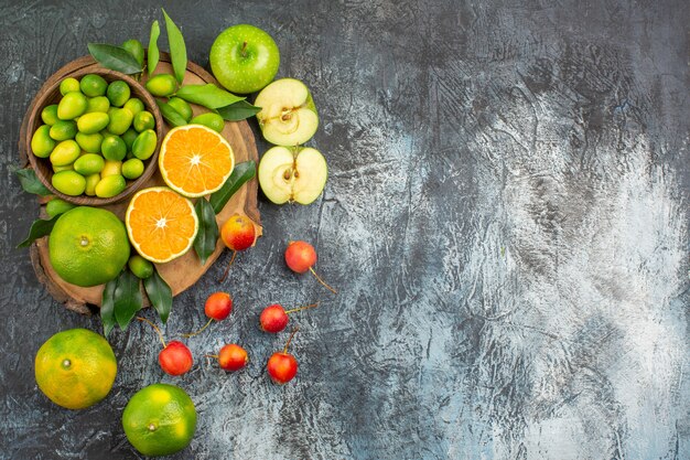 Top view from afar fruits the appetizing apples citrus fruits on the cutting board cherries