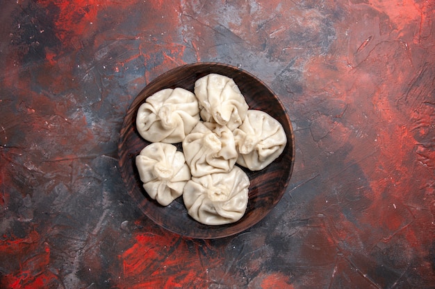 Top view from afar khinkali bowl of the appetizing khinkali on the red-grey table