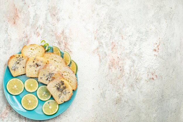Foto gratuita vista dall'alto da lontano pane al limone pane bianco con erbe limone nel piatto sul tavolo