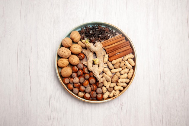 Вид сверху орехи и корица грецкие орехи фундук палочки корицы арахис и звездчатый анис на столе