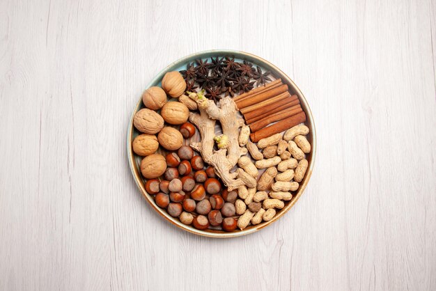 Top view from afar nuts and cinnamon walnuts hazelnuts cinnamon sticks peanuts and star anise on the table