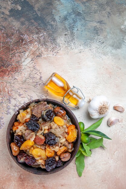 Top view from afar pilaf bowl of an appetizing pilaf bottle of oil citrus fruits garlic