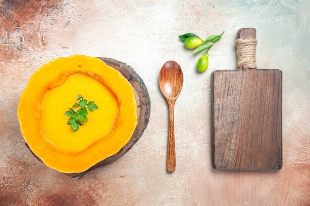 Top view from afar a soup pumpkin soup on the board next to the spoon the cutting board